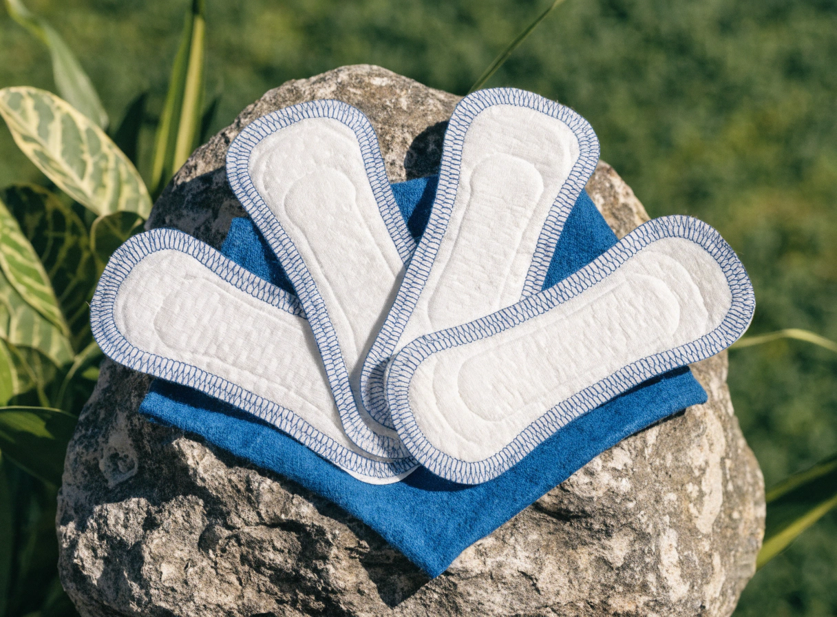 Several sanitary pads placed on a pink background.